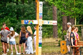 Ein stählerne Kreuz, versehen mit individuell gestalteten Holzbrettchen, begleitete die Kinder während ihrer Aktivitäten im Konfi-Camp 2024. 	Foto: Konfi-Camp