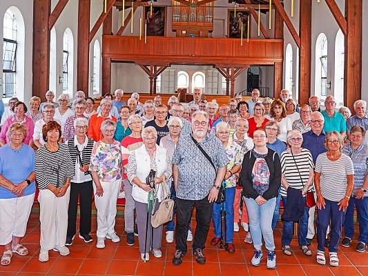 Die 66 Teilnehmenden an der achttägigen Inselfahrt Borkum haben sich nach dem sonntäglichen Gottesdienst in der evangelisch-lutherischen Christuskirche, der Borkumer Kirche unter dem Neuen Leuchtturm, zu einem Erinnerungsfoto aufgestellt. Vorausgegangen war ein beeindruckender, musikalisch vielseitiger Gottesdienst. Foto: Andreas Behr, Borkum